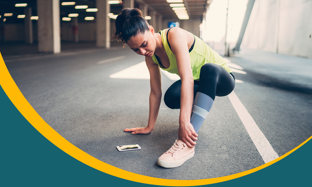 female runner holding ankle